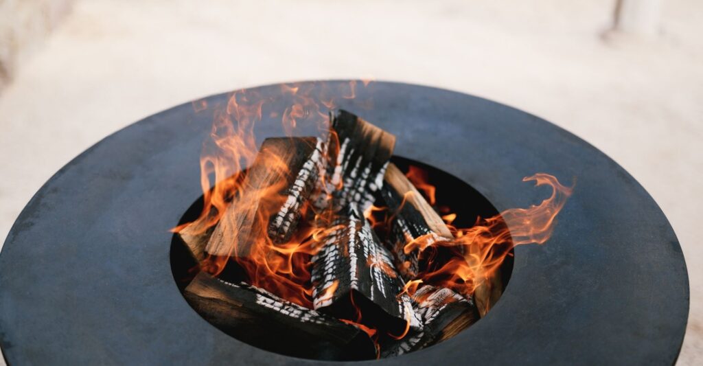 A fire pit with logs burning inside it