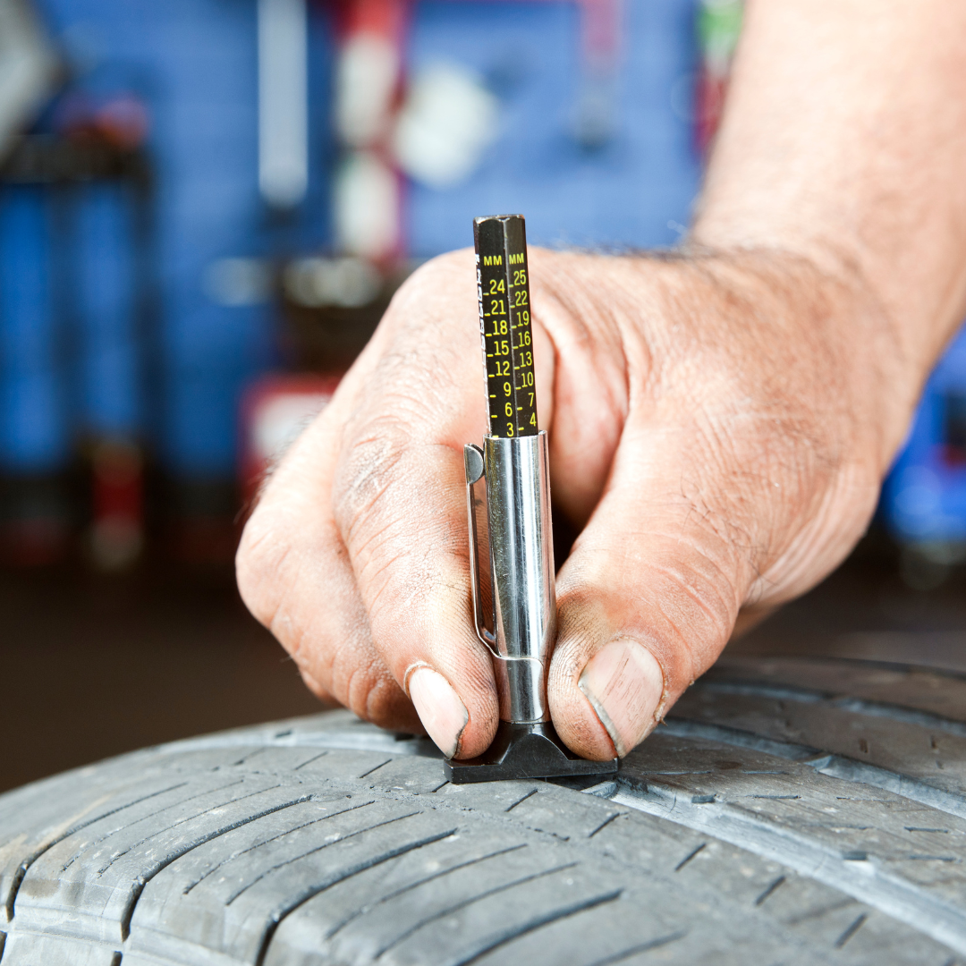 someone checking the treads on their tires