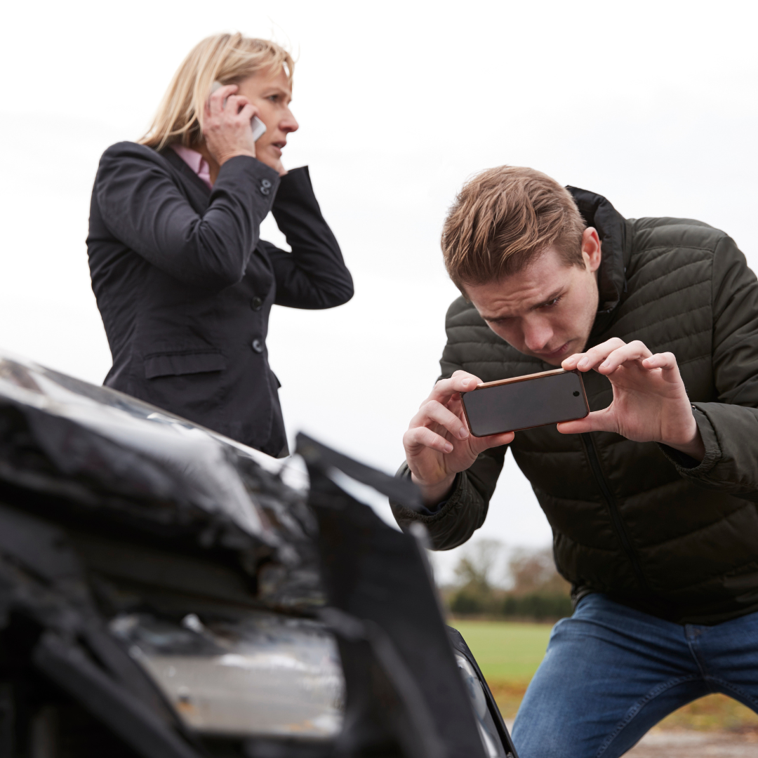 man taking pictures of damage after an accident