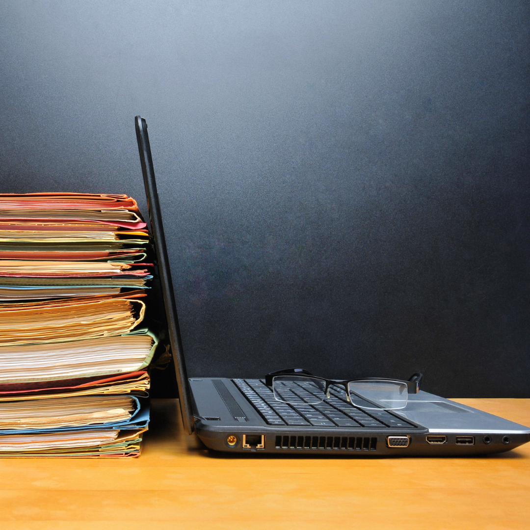 folders with documents sitting next to a laptop