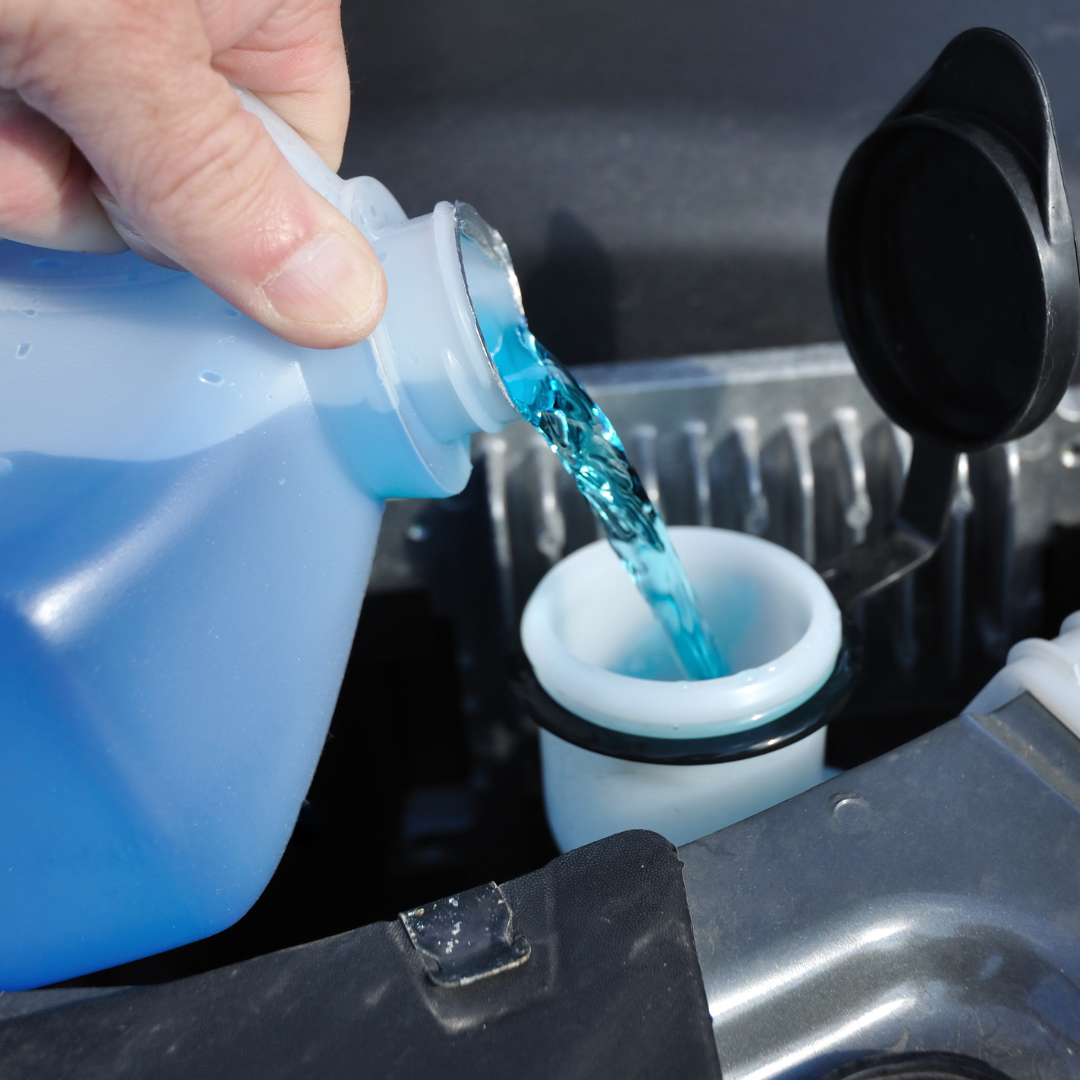 pouring wiper fluid into car engine