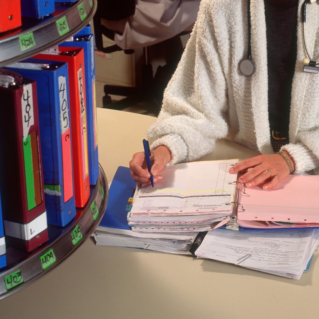 Medical professional writing in record book