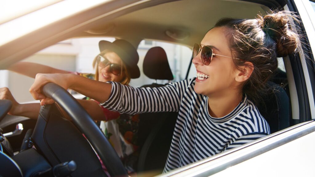Two young women driving.