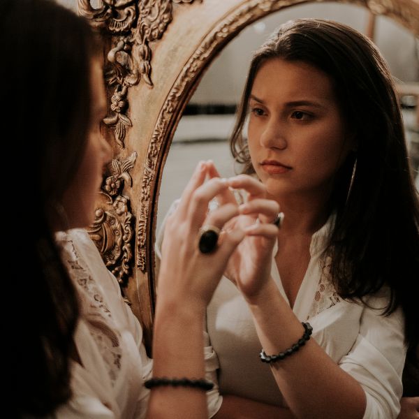 photo of girl looking in mirror