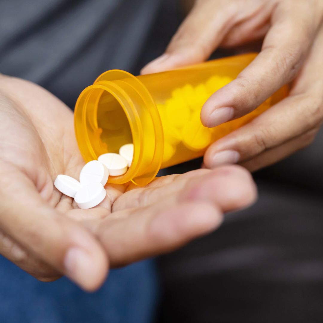 Someone pours pills from a bottle