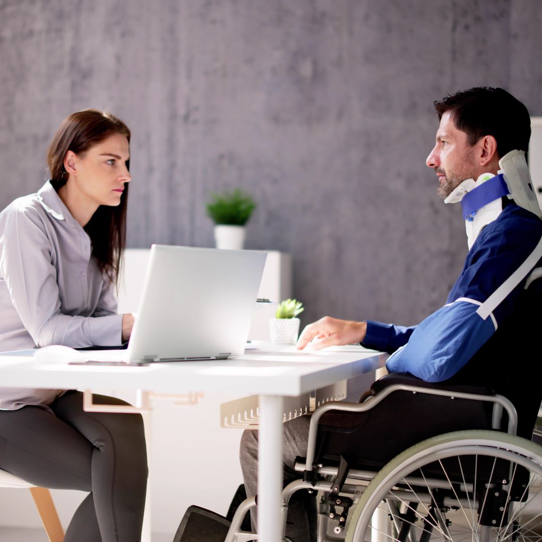 A lawyer meets with a client in a wheelchair