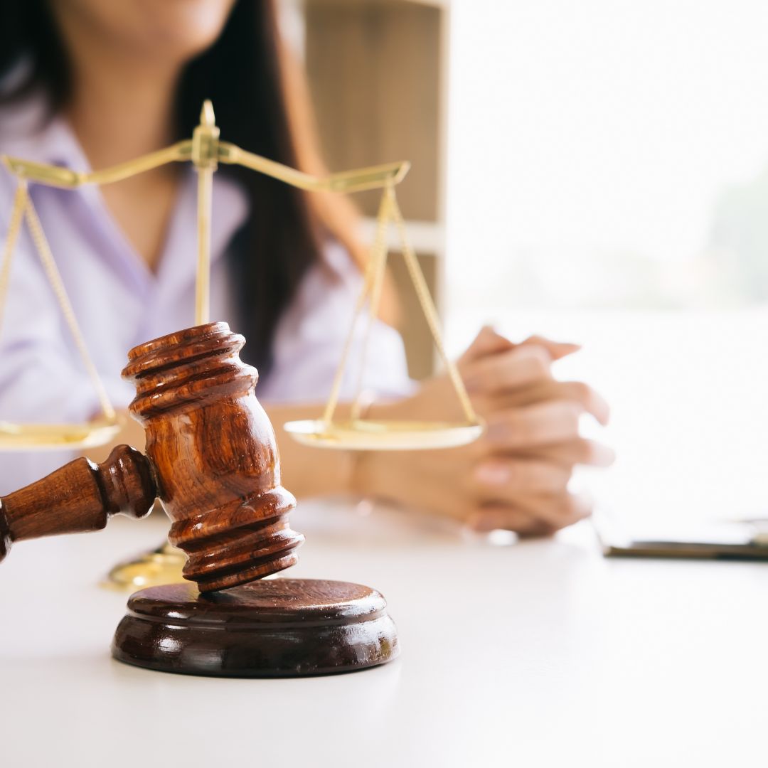 A lawyer sits in front of a gavel