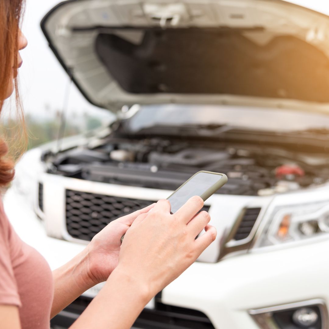 woman using phone outside of car