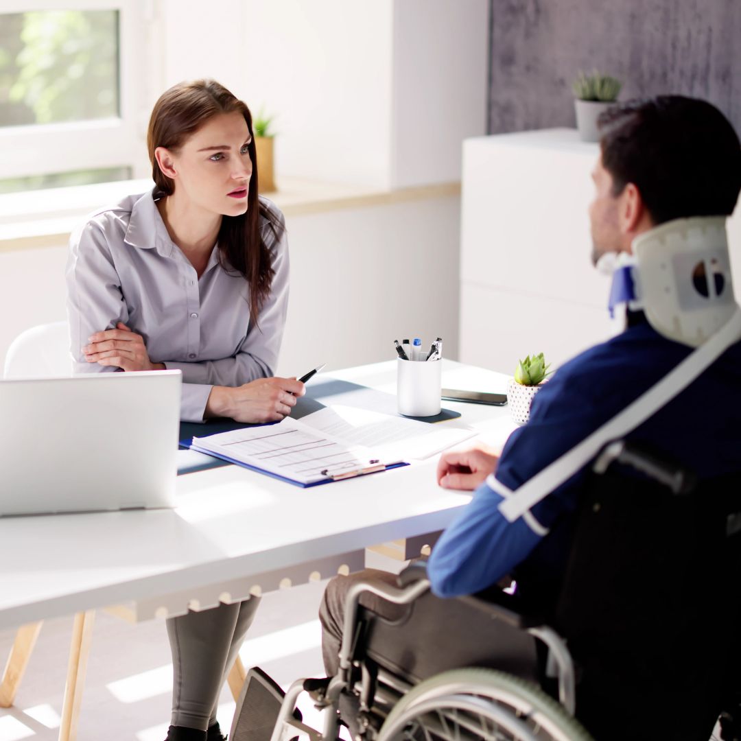 attorney talking to client in wheelchair