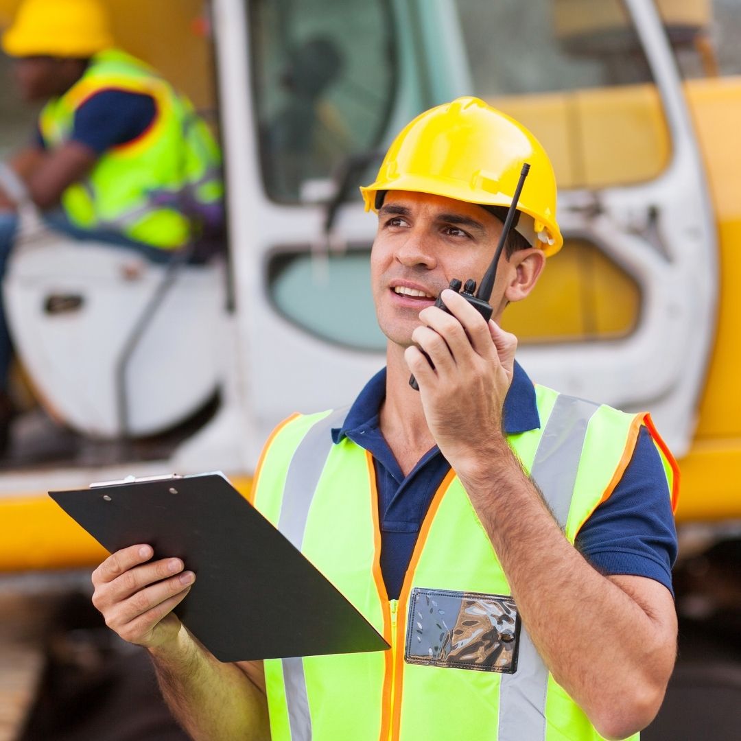 man speaking on radio at a construction site