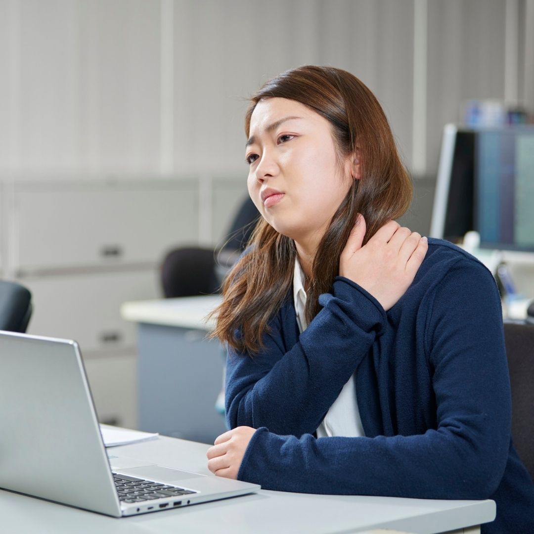 woman in pain while at work at her desk