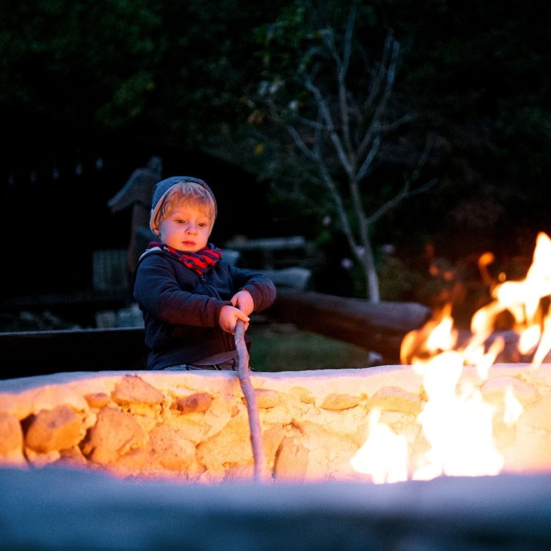 A child poking a fire with a stick