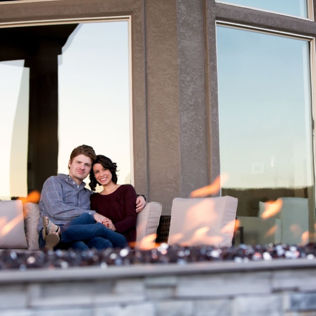 A couple sitting by their patio fire pit
